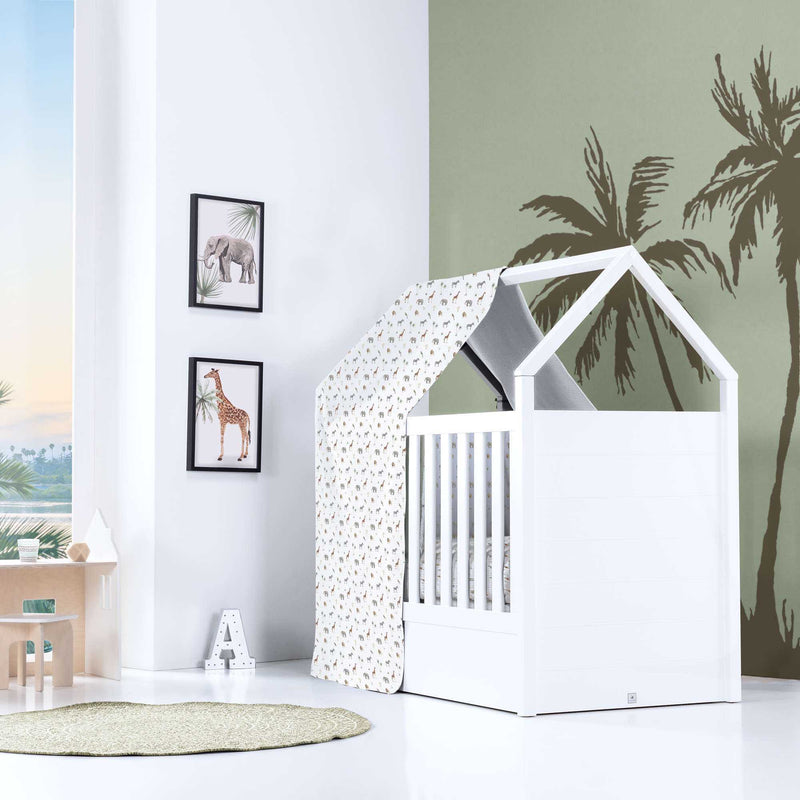 Cuna Montessori en forma de cabaña en blanco con toldo estampado de jungla