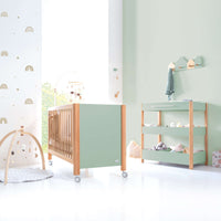 Habitación de bebé con cuna y cómoda-cambiador en verde menta aqua y madera inspiración