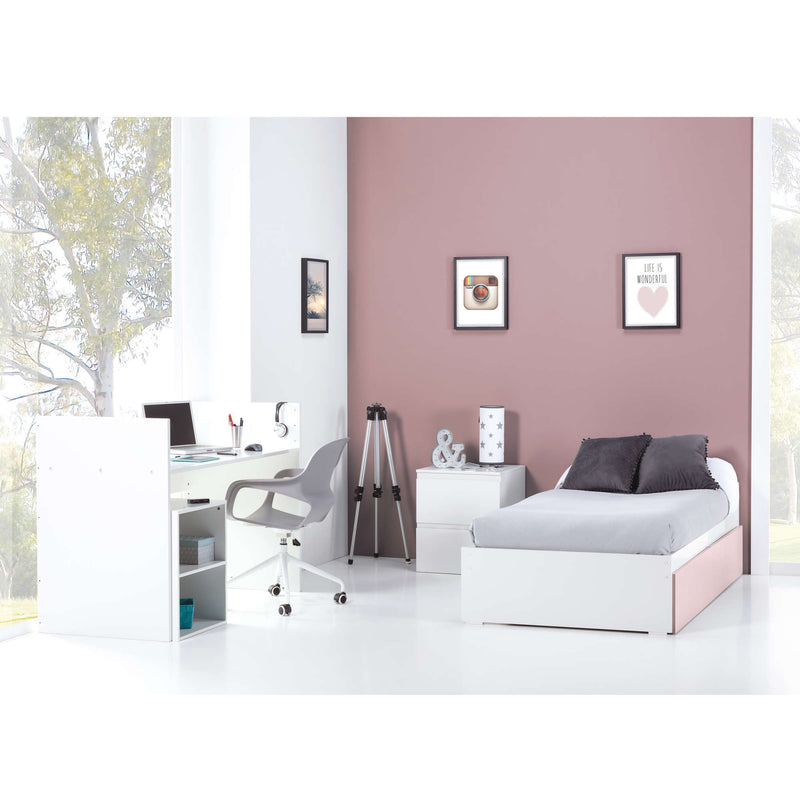 Cuna de bebé desmontada en habitación con cama y escritorio color rosa